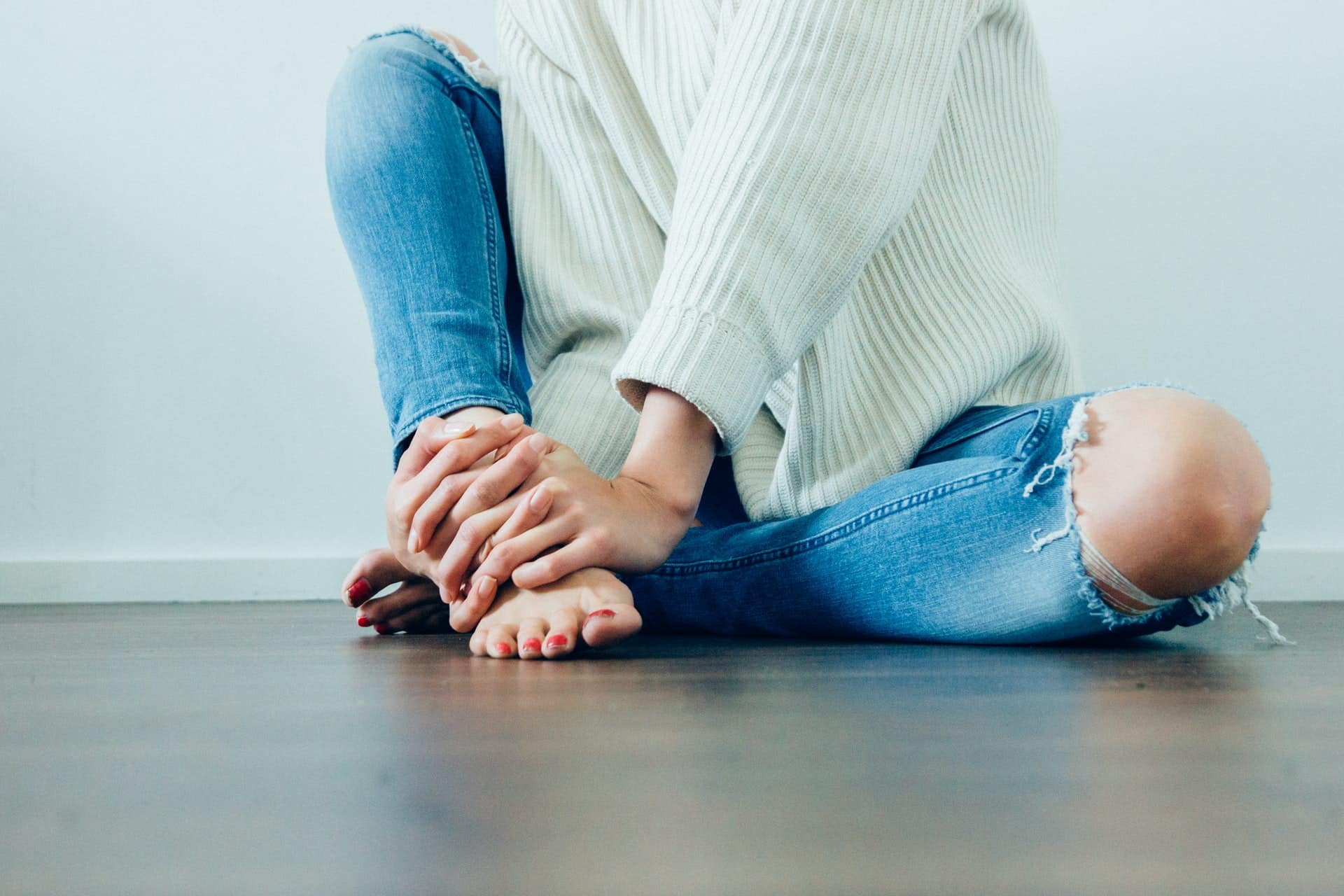 woman sitting on floor with leg pain